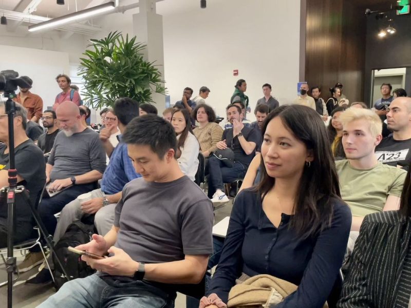 A group of people sitting in a room for an AI event.