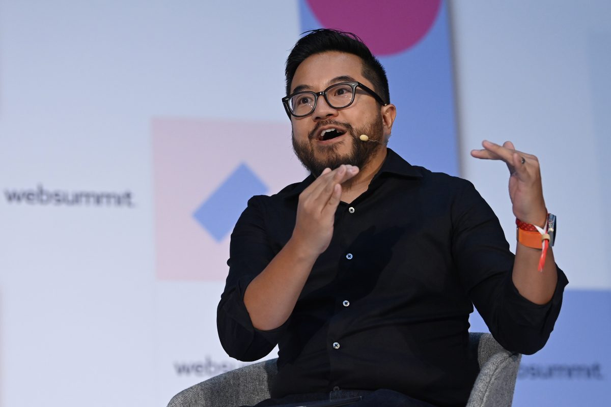 Garry Tan sitting in a chair on stage, gesticulating with his hands