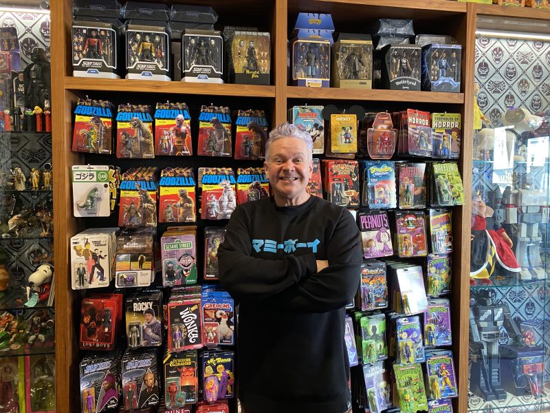 A man standing in front of a display of action figures.