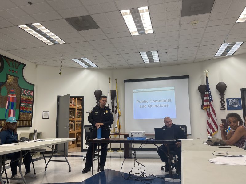 Captain Maron stands before his presentation, aided by Officer Dave Correa.