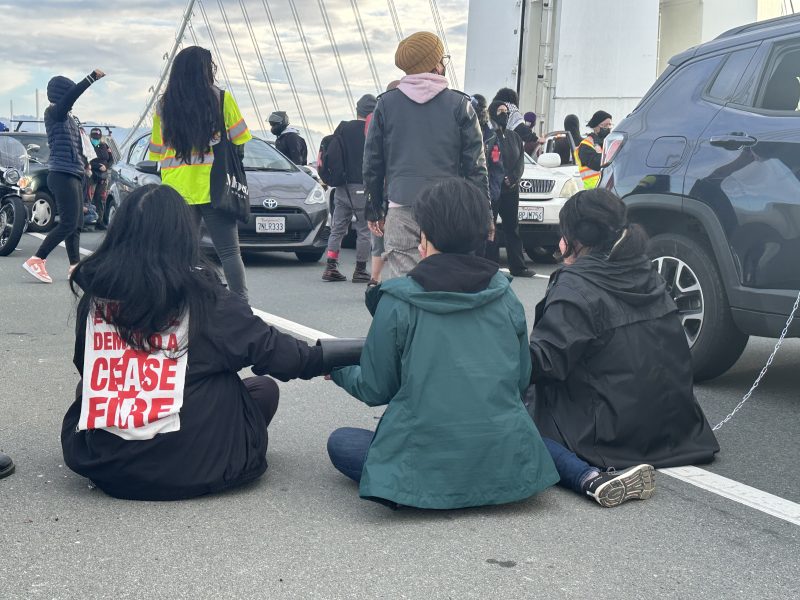 A group of people sitting on the side of the road.