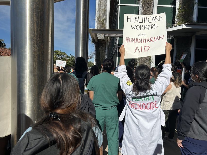 A group of people holding signs in front of a building.