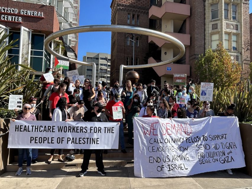 A group of people holding signs in front of a building.