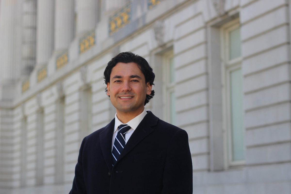 A man in a suit standing in front of a building.