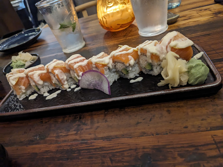 A plate of sushi on a wooden table.