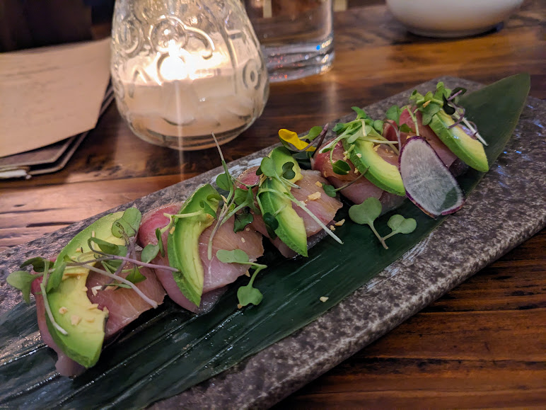 A plate of sushi on a wooden table.
