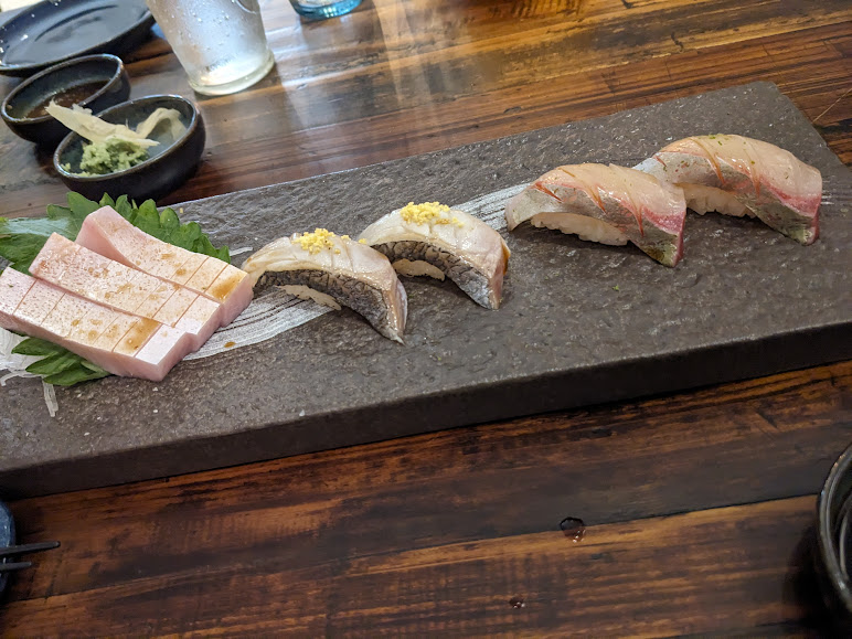 A platter of sushi on a wooden table.