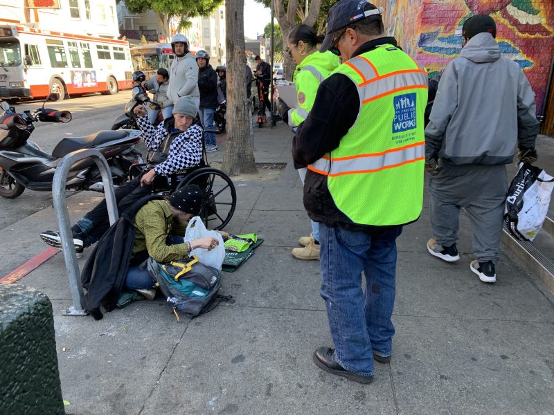 A group of people on a sidewalk.