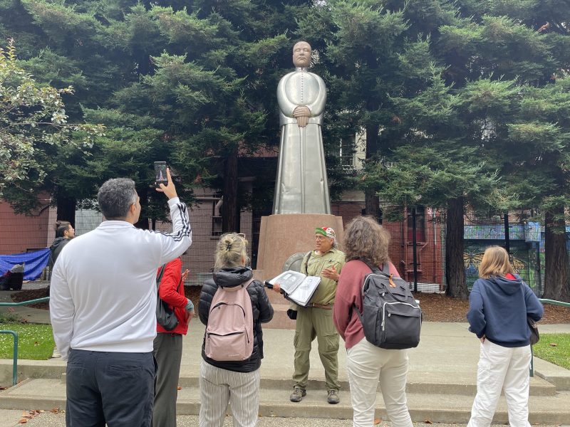 Giesen stands before the statue of Sun Yat-sen in St. Mary's square, discussing the history behind the figure to his tour group.