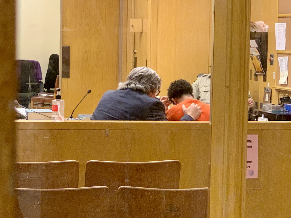 Two people sitting in a courtroom.