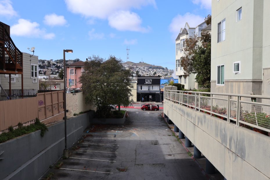 An alleyway with a car parked next to it.