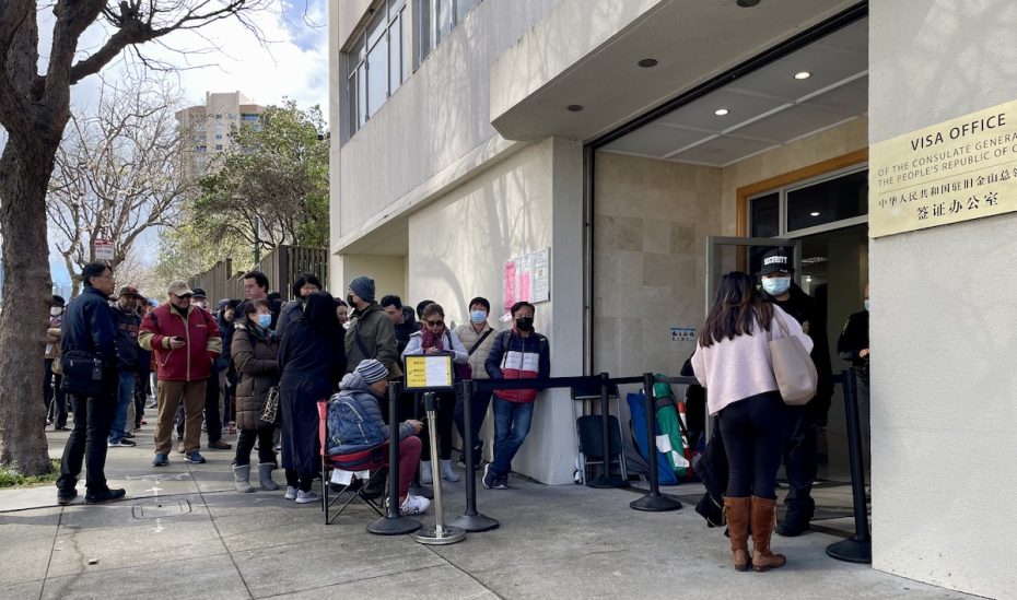 A group of people waiting in line in front of a building