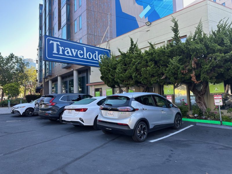 A Travelodge sign hangs over the cars parked at Central Hotel
