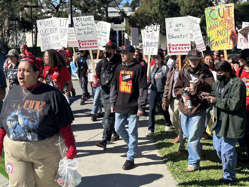 A group of faculty and students marching on San Francisco State University campus.