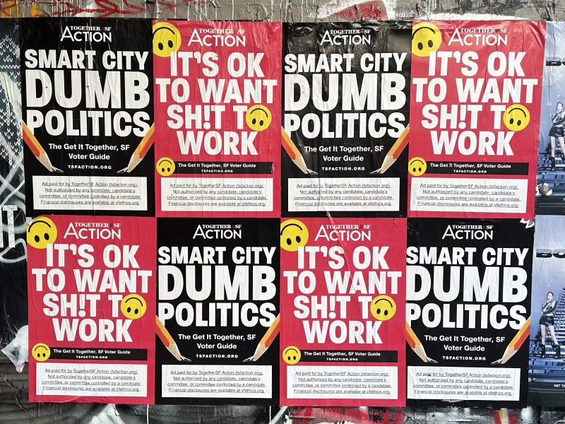A group of posters with the words "Smart city dumb politics" and "It's OK to want shit to work"