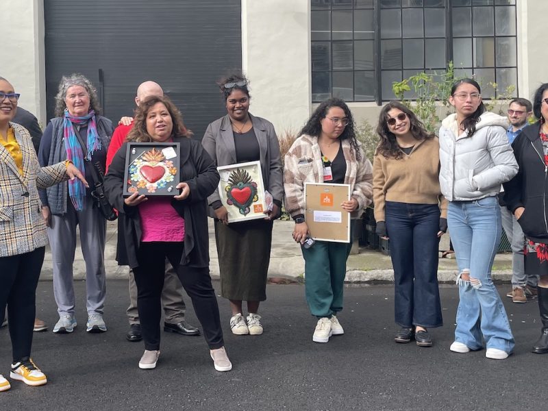 A group of women holding artworks.