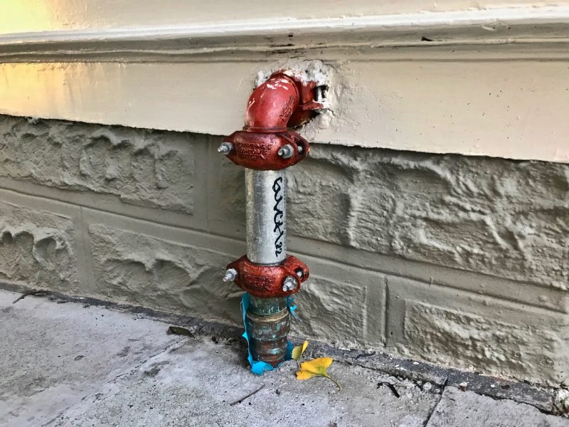 A pipe on the side of a building.