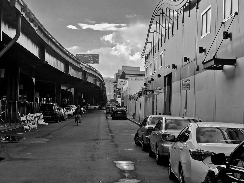 A black and white photo of cars parked on a street.