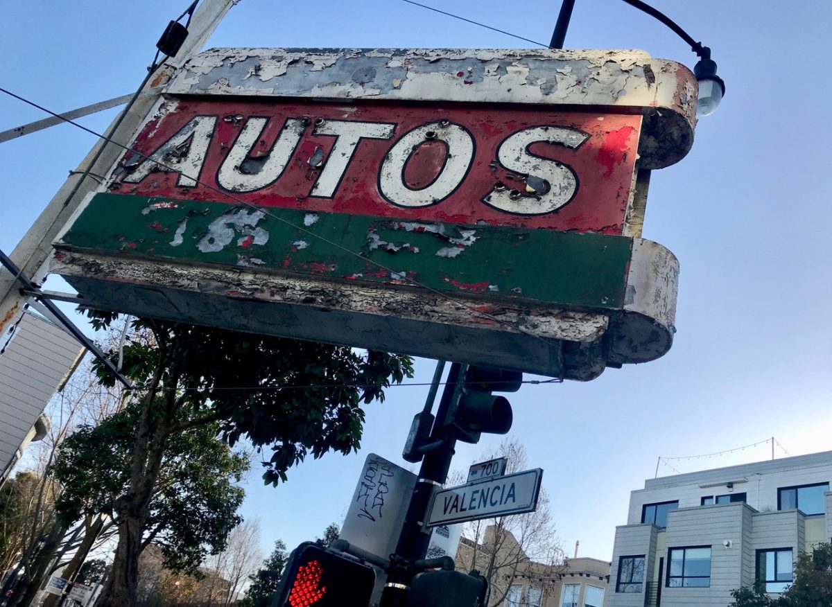 A rusty sign that says autos.
