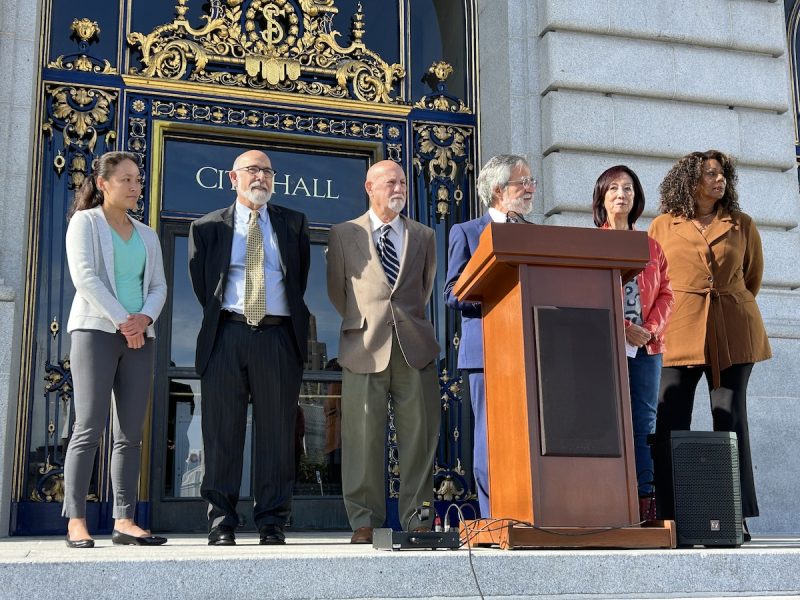 A group of people standing in front of an ornate building.