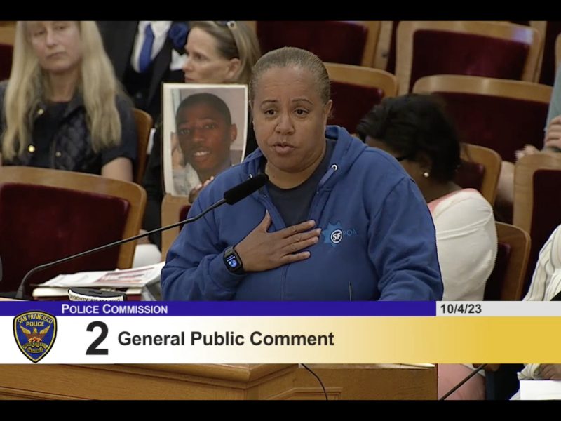 A woman is speaking in front of a group of people.