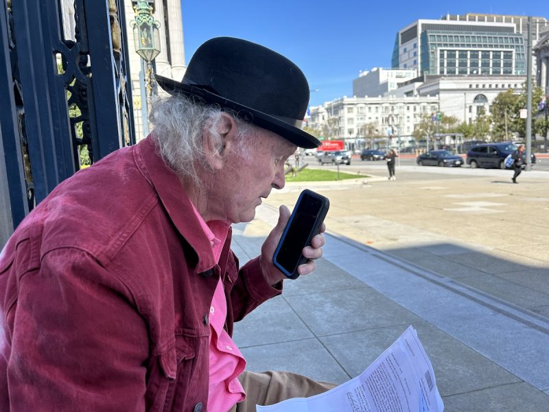 A man sitting on a bench on the phone and reading his foreclosure notices.