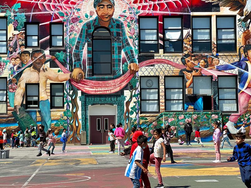 A big mural overlooking a playground where children are playing.
