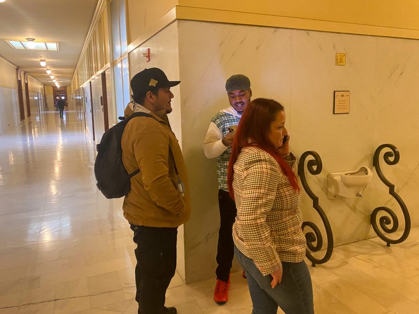 Three former workers at SF SAFE standing in a hallway at City Hall.