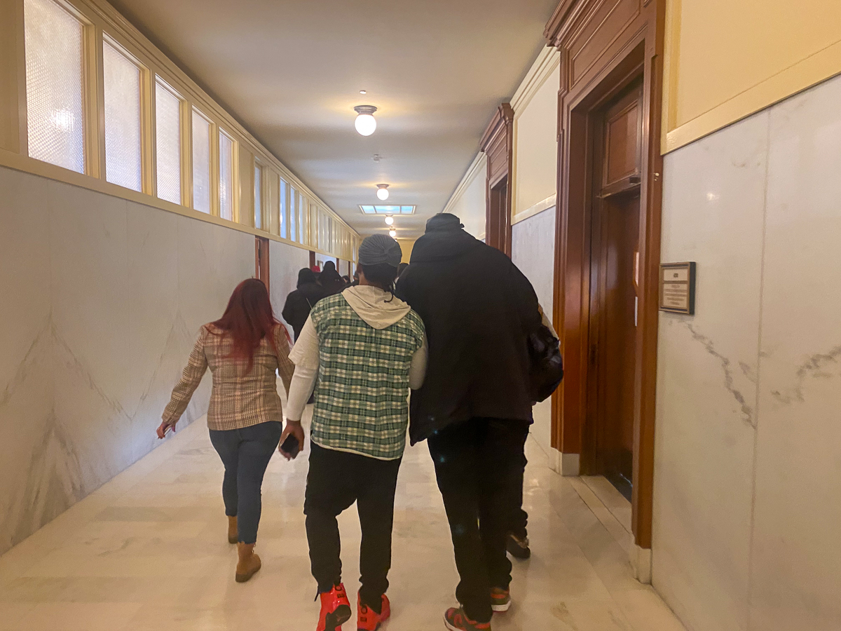 A group of former SF SAFE workers walking down a hallway at city hall heading to a meeting with the Office of Labor Standards Enforcement