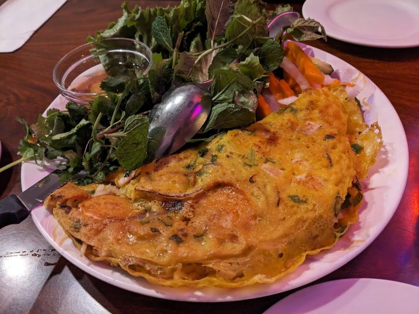 An omelet on a plate with vegetables on it.