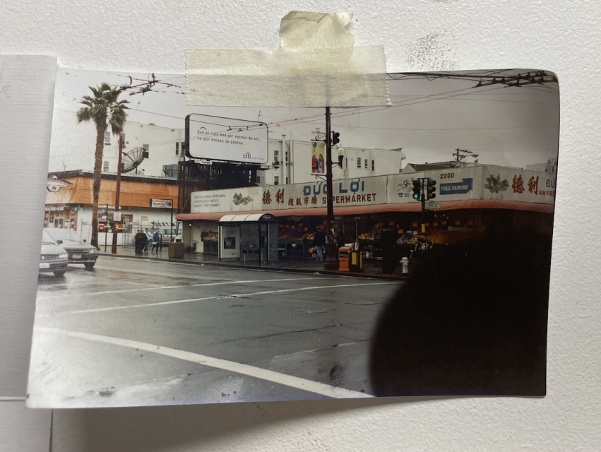 A picture taped on a wall of a supermarket with Duc Loi signage.